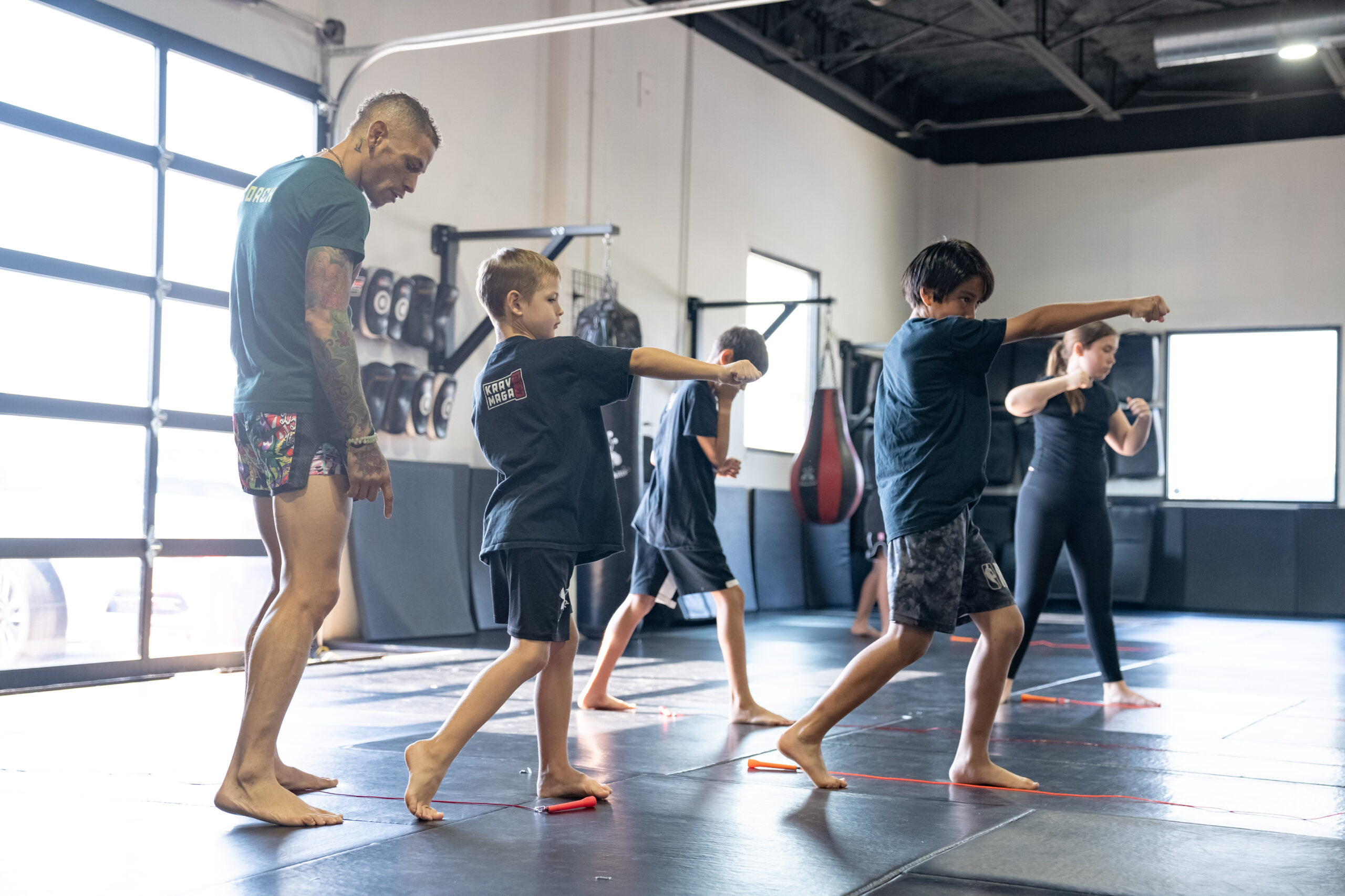 Young Warriors students practicing punches under instructor supervision