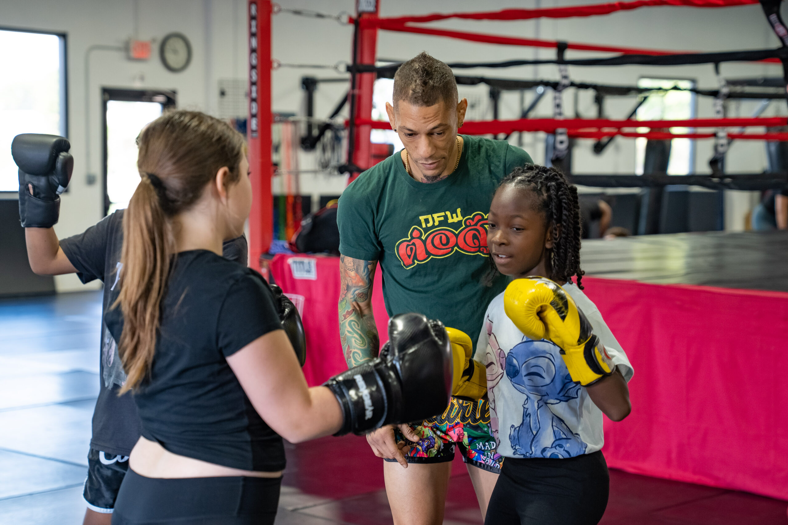 Instructor guiding Young Warriors students through a boxing glove drill