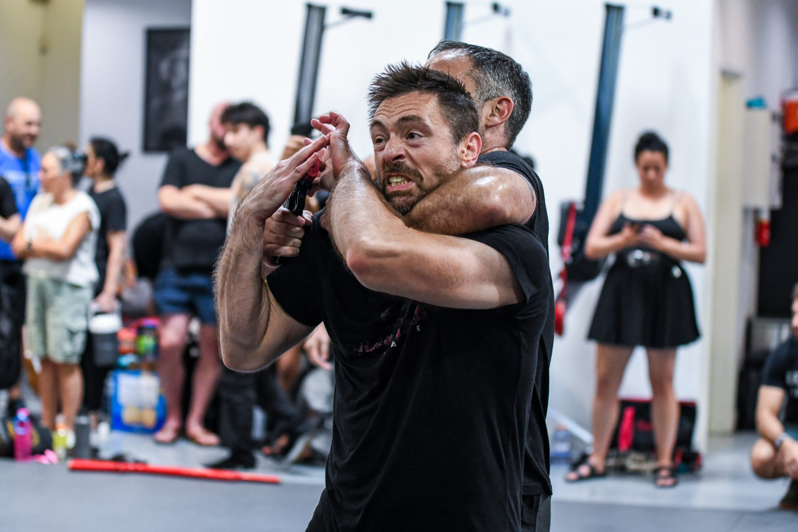 Instructor demonstrating a standing partner exercise to the class